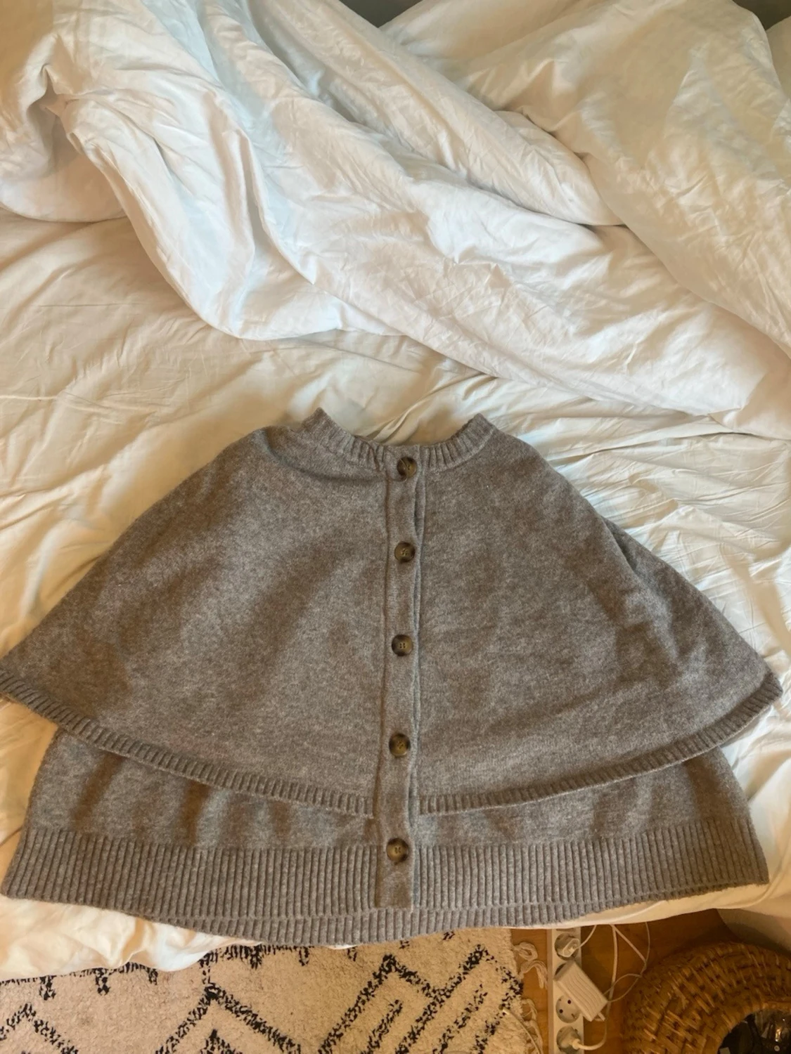 Grå stickad cape med knappar