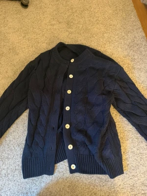 Mörkblå kabelstickad kofta Gina Tricot - Marine blå kofta med knappar. Ganska lång och oversized men väldigt mysig. 