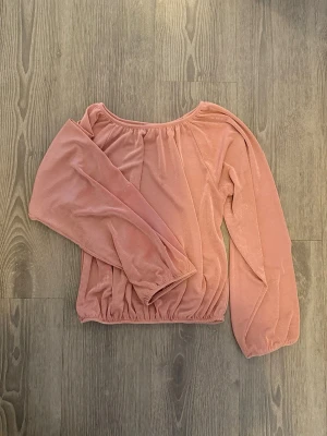 Rosa offshoulder från Gina Tricot XS - Säljer en söt rosa offshoulder topp från Gina Tricot i mjuk sammet. Toppen har långa, puffiga ärmar och resår i nederkant och vid axlarna för en snygg passform. Väldigt stretchig.