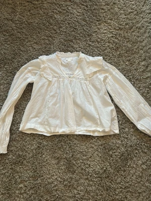 Vit blus med spets från Gina Tricot - Söt vit blus från Gina Tricot med volangkrage och spetsdetaljer vid bröstet och ärmarna. Använd en gång och i väldigt bra skick❤️
