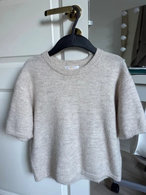 Beige stickad tröja  - Mysig beige stickad kortärmad tröja från Gina Young.Perfekt att matcha med jeans eller kjol. 