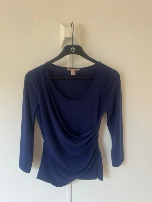 Marinblå draperad topp Anna Field - Snygg marinblå topp från Anna Field med draperad front och trekvartsärm. Toppen har en mjuk, stretchig känsla och en smickrande passform med lätt rynkning i sidan. Perfekt till jeans eller kjol för en trendig look. Snygg passform. 