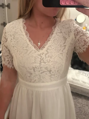 Vit spetsklänning med kort ärm - Superfin vit klänning med spets upptill och korta ärmar. Använd 1 gång! Passar superbra till student eller konfirmation💞 