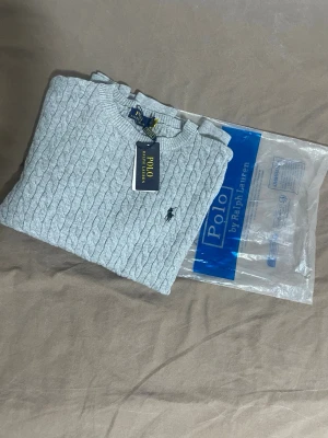 Ljusgrå kabelstickad tröja Polo Ralph Lauren - Helt ny ljusgrå stickad Ralph Lauren tröja, mjuk och bekväm. Klassisk design med Ralph Laurens ikoniska logga.   Skick [10/10] Storlek [M] Säljes för [599]  Hör av dig om du vill ha fler bilder eller info!🥂