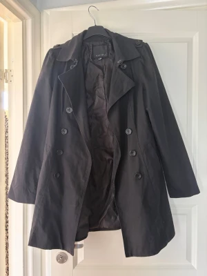 Lång svart trenchcoat  - Stilren svart trenchcoat, utan bälte. Pris går att diskutera 💕