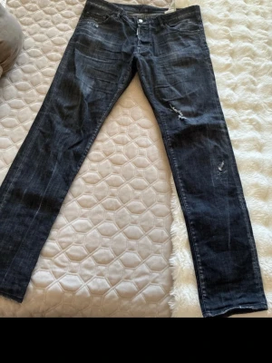 grå  dsq2 jeans! - Säljer ett par grå svarta dsq jeans med  orange text på baksidan!. Jeansen har klassisk femficksmodell, dragkedja och knapp i midjan. Snygga detaljer med slitna partier på låret och knät. Perfekta för en avslappnad och trendig stil. kvittot finns nånstans på mailen köpta från johnells, stl 54 motsvarar 38 i midja men passar folk som har 34/36 om man har bälte utan problem och passar 32 i längden!, cond 9/10 slutsålda överallt finns inte kvar jätte sällsynta jeans! nypris är runt 5000- 6000 ish! 