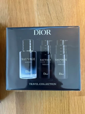Dior Sauvage Travel Collection set - Säljer ett exklusivt Dior Sauvage Travel Collection set med tre flaskor. Setet innehåller Eau de Parfum, The Cleanser och The Serum i snygga flaskor i svart och blått. Perfekt för dig som vill ha lyxig doft och hudvård i praktiskt format från Dior. Dior Sauvage Eau de Parfum Parfymset  