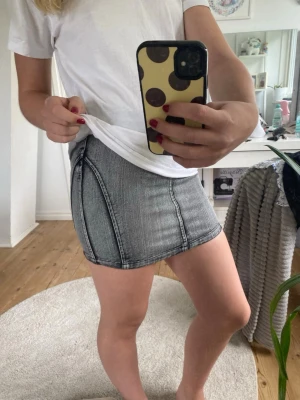 Grå jeanskjol från Skill - Grå jeans kjol, väldigt snygg och skön till sommaren knappt använd men köpt för längesen.