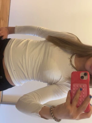 Vit långärmad tight topp - Säljer en vit långärmad topp i stretchigt material. Modellen är figurnära och har rund halsringning. Perfekt att styla med jeans eller kjol för en enkel och clean look.