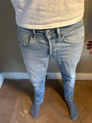 Ljusblå dondup jeans  - Säljer ett par ljusblå slim fit jeans från dondup Jeansen har snygga slitningar.