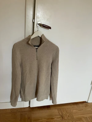 Beige stickad half zip-tröja - Säljer en beige hall zip tröja från märket Riley i storlek M, endast använd 2 gånger då ja inte tycker att den passar mig. Nypris ligger runt 800 kr 