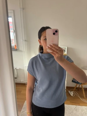 Ljusblå ribbad polotopp - Säljer en ljusblå ribbad polotopp med korta ärmar. Toppen har en mjuk, stretchig känsla och en högre krage som ger en clean look. Perfekt att styla med jeans eller kjol för en chill vibe. Köpt på Zalando för några år sedan, men har inga tecken på användning. Den ljusblå färgen passar utmärkt till våren☀️🍉❤️ 