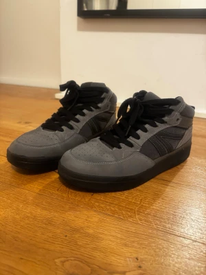 Gråa och svarta high top sneakers pull&bear - Snygga high top sneakers i grått och svart med svarta skosnören och detaljer. Ovandelen är i en mix av mockaliknande material och textil, med perforeringar på tån för extra stil. Perfekta för dig som gillar en clean och urban look.