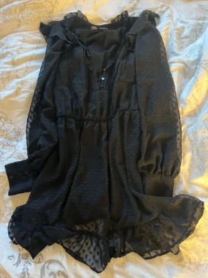 Svart Zara Klänning - Jätte fin svart volang klänning från Zara perfekt till sommaren, säljer pga för liten!