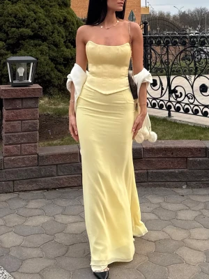 Ljusgul lång satinklänning - Supersnygg ljusgul lång klänning i satin från Oh Polly axelband och figurnära passform (axelband finns att sätta i om man vill). Klänningen har en enkel, elegant design med lätt glansigt material och markerad midja. Perfekt för dig som vill sticka ut med en fräsch och trendig look.