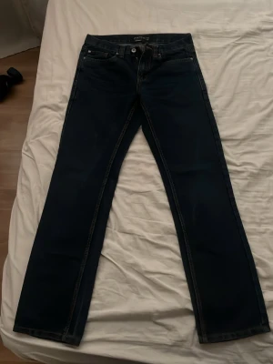 Mörkblå raka jeans från IDENTIC (W30,L32) - Snygga mörkblå jeans från Identic med raka ben och klassisk femficksdesign. Jeansen har kontrastsömmar och normal midja. 