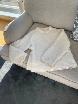 Vit fluffig stickad tröja -  Säljer denna tröja från Gina Tricot nypris 399 kr. Den har en fläck i mitten men går att tvätta bort i handtvätt annars fint skick. Säljer för 50 kr då jag vill få iväg den