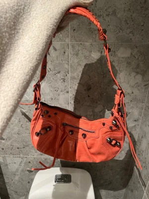 Orange axelväska  - Snygg axelväska i baguette modell. Justerbara band. Använd en gång 