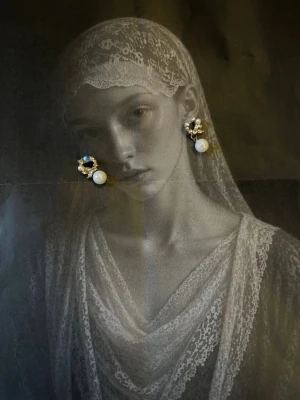 Guldörhänge med pärlor och kristaller - Snyggt örhänge i guldton med dekorativa små kristaller och en hängande vit pärla. Designen är blommig och elegant, perfekt för dig som gillar unika accessoarer med lite extra detaljer. Materialet är troligen metall och pärla.