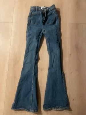 Blå utsvängda jeans från 157 - Snygga blå jeans med utsvängda ben från 157. Klassisk femficksmodell med hög midja och raka sömmar. Perfekta för dig som gillar retrostil och vill sticka ut med en cool siluett. Jeansen är i mjukt denimtyg och har en avslappnad passform.