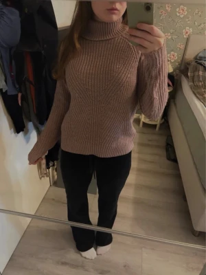 Stickad polotröja i gammelrosa - Smutsrosa stickad tröja med hög krage. Fint stickat mönster framtill. Mycket fint skick. Från Jacqueline de yong.