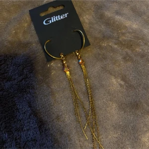 Guldörhängen med kedjor - Snygga guldörhängen från Glitter med långa kedjor som hänger ner. Säljes pga kan ej använda dem! Mäter och fler bilder vid förfrågan! ✨