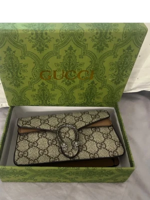 Axelväska - Oanvända axelväska med band, dustbag ingår