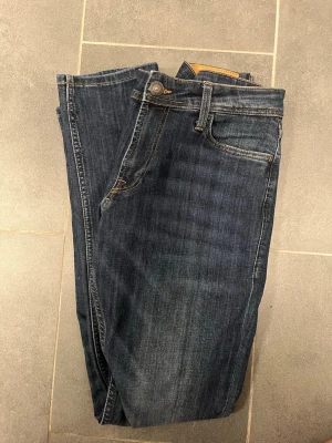 Mörkblå jeans från Stock & Hank - Snygga mörkblå jeans från Stock & Hank med klassisk femficksmodell och kontrastsömmar. Jeansen har en rak passform och är tillverkade i slitstarkt denimtyg. Perfekta för dig som gillar en tidlös och enkel stil.