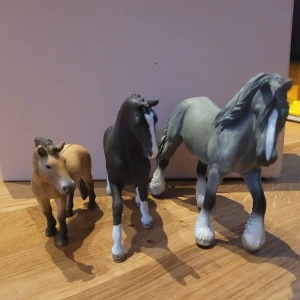 Hästar  - Säljer tre detaljerade hästar i märket Schleich. En är ljusbrun med mörk man och svans, en är svartbrun med vita ben och bläs, och en är grå med vit mule och ben. Perfekta som dekoration, samlarobjekt eller leksaker för dig som gillar hästar.
