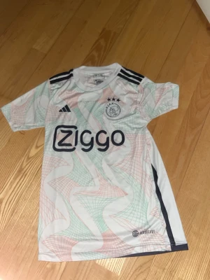 Ajax vit matchtröja Adidas - Säljer en vit Ajax bortatröja från säsongen 22/23. Tröjan är i bra skick. Storleken är 152 vilket äs XXS