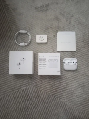 Apple AirPods 2 - Säljer ett par vita Apple AirPods Pro med trådlöst laddningsetui. Hörlurarna har en stilren och kompakt design i plast, perfekt för dig som vill ha grymt ljud och brusreducering. Allt originaltillbehör som laddkabel och manualer ingår.