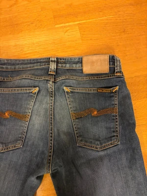Mörk Blå slim jeans från Nudie Jeans - Ett par feta Nudie Jeans som är slim fit. Det finns ett litet hål på vänstra benet men man vi märker inte det.