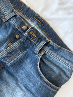  Nudie Jeans - Nudie solid Ollie st 30/32, sparsamt använda  men har ett litet hål på baksidan vid skrevet( syns i bild) går att laga gratis hos nudie eller billigt hos en annan skräddare