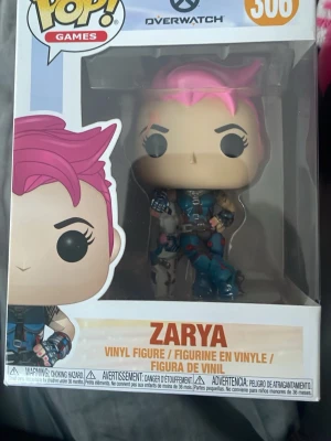 Funko Pop Zarya Overwatch figur - Säljer en Funko Pop vinylfigur av Zarya från Overwatch, nummer 306. Köpte denna runt 2019 och har ej tagits ur lådan.