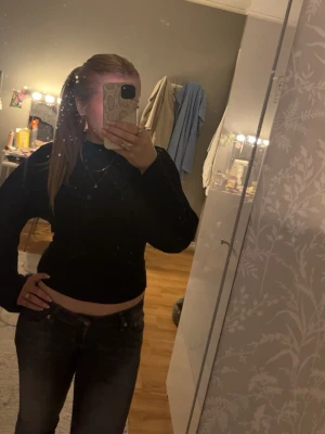 Svarta raka jeans med låg midja - Säljer ett par svarta jeans med raka ben och låg midja. Jeansen har klassiska fickor både fram och bak samt bälteshällor. Perfekta till en avslappnad och trendig stil. Materialet är denim i bomull.