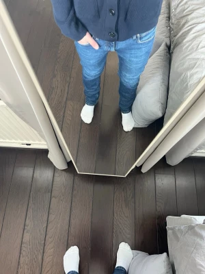 Blå slim fit jeans med normal midja - Säljer ett par klassiska blå slim fit jeans med normal midja och fem fickor. Jeansen har en snygg tvätt och raka ben. Perfekta för dig som gillar en enkel och stilren look. Materialet är mjukt och stretchigt för extra komfort.