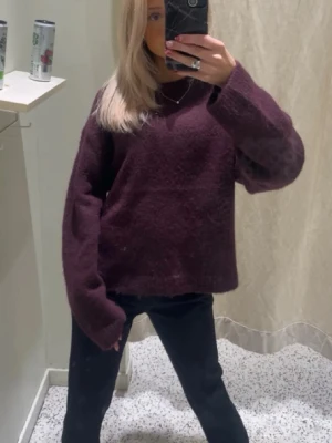 Stickad tröja - Säljer en stickad tröja i vinröd/mörklila färg. Tröjan har långa ärmar och rundad halsringning. 