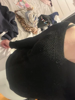 Svart stickad tröja med v-ringning - Säljer en svart stickad tröja med snygg v-ringning och långa ärmar. Tröjan har en avslappnad passform och är perfekt för lager på lager. Passar till både jeans och kjol för en enkel, stilren look.