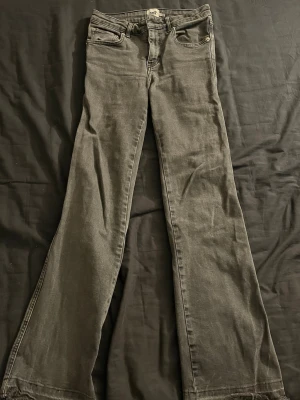 Svarta bootcut jeans från lager 157 - Säljer ett par svarta straight jeans från lager 157 med råa, fransiga benslut och klassiska fem fickor. Perfekta för en avslappnad och trendig look.