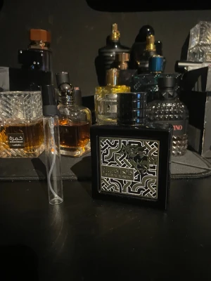 Oud Al Fursan parfym 10 ml - Snygg parfym i svart fyrkantig flaska med silvermönstrad etikett och dekorativ häst. Flaskan har en svart, rund kork och ger ett lyxigt intryck. Perfekt för dig som gillar unika och eleganta dofter.