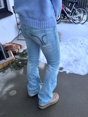 Lågmidjade bootcut jeans med hål - Bootcut jeans med hål, låg midja och snygga slitningar och tvätt. Står storlek L men passar S/M.  Midjemått: 80 cm Innerbenslängd: 82 cm  95% bomull 5% elastan