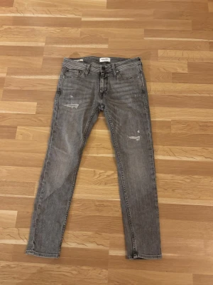Grå Jack & Jones jeans - Säljer dessa grå Jack & Jones jeans i sjukt bra skick. Storlek 31/30, hör av dig vid frågor!