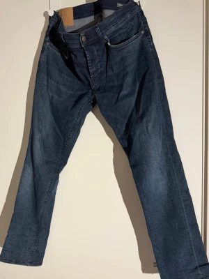 Dondup George Jeans - Säljer ett par mörkblå Dondup George jeans med rak passform och klassisk femficksdesign.  W33 uppsydda till 30 i längd.