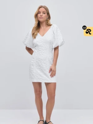Vit kort klänning med puffärm - Superfin vit kort klänning med v-ringning och puffiga kortärmar. Klänningen har en strukturerad yta och figurnära passform som ger en trendig look. Perfekt för sommarens alla tillfällen!