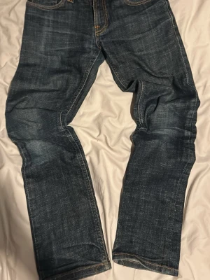 Mörkblå raka jeans - Säljer ett par mörkblå jeans med raka ben och klassisk femficksdesign. Jeansen har kontrastsömmar och en snygg tvättad look som ger en avslappnad vibe. Perfekta till sneakers och hoodie för en casual stil. Prislapp följer inte med då bilderna va gamla och har slängt de