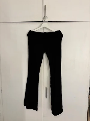 Svarta bootcut leggings - Säljer ett par svarta leggings med bootcut-modell och bred linning. De är stretchiga och sitter skönt på kroppen, perfekta till en avslappnad stil. Materialet känns mjukt och följsamt, troligen bomull eller bomullsblandning. Passar dig som gillar enkel och clean look.