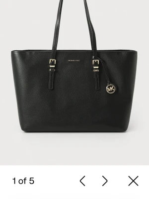 Svart toteväska Michael Kors (äkta)  - Stilren svart toteväska från Michael Kors i slätt läder med guldfärgade detaljer och dubbla axelband. Väskan har en klassisk rektangulär form och ett hängande MK-emblem i metall. Perfekt för dig som gillar en enkel men lyxig look. Om ni vill ha mer bilder eller mer bevis på att de är en äkta är det bara och skriva💕Nypris är 2800kr! Pris kan diskuteras💕denna är även helt oanvänd