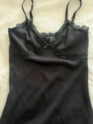 Svart ribbad klänning med spetskant - Superfint ribbad klänning från hm med spetskant. Helt oanvänd med lapp kvar