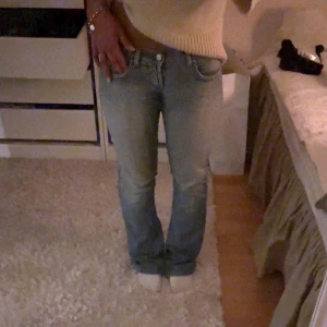 Ljusblå bootcut jeans - Säljer ett par ljusblå bootcut jeans med låg midja. Jeansen har en avslappnad passform och är tillverkade i denim med lätt tvättad look. Perfekta för en casual och trendig stil.