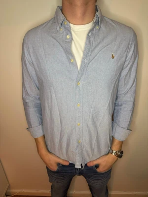 Ljusblå Ralph Lauren Custom skjorta  - Hej! Vi säljer på Studio II Resell säljer nu denna Ralph Lauren Custom fit skjorta i storlek M och i nyskick!😊 Vårt pris 299kr men kan gå ner vid snabb och smidig affär💙 // Studio II Resell 